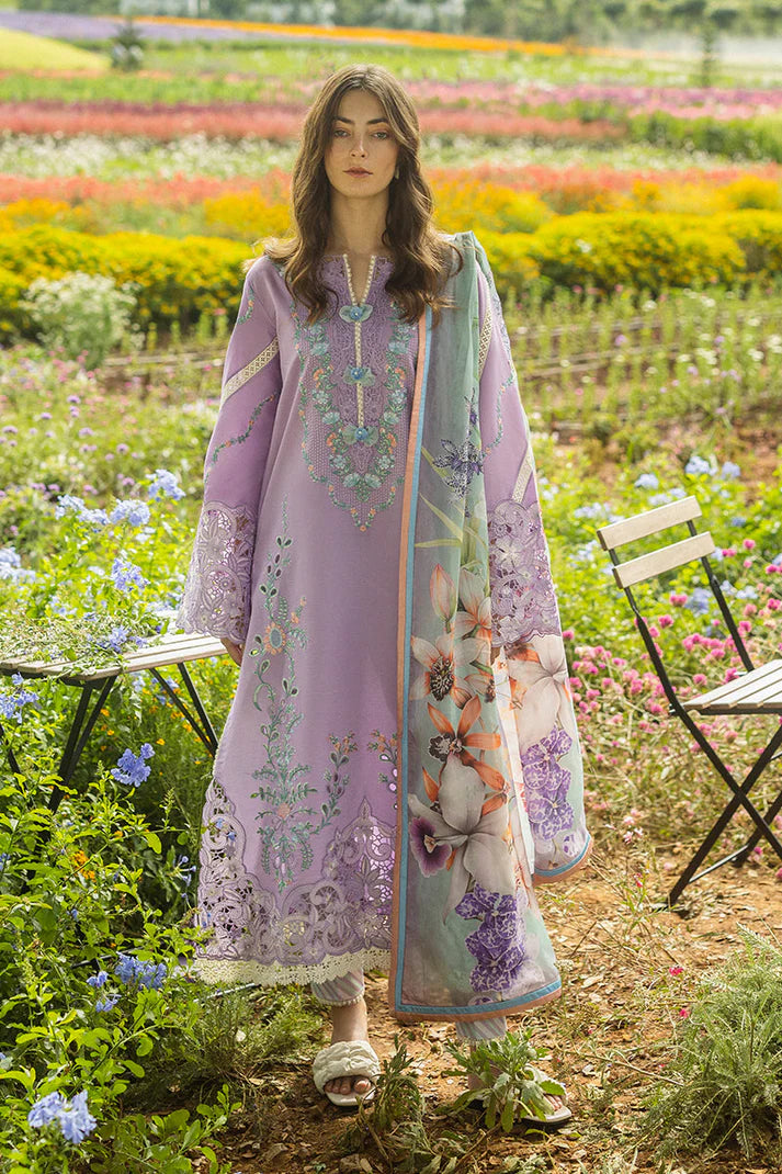 Woman in a lavender embroidered outfit standing in a colorful flower field