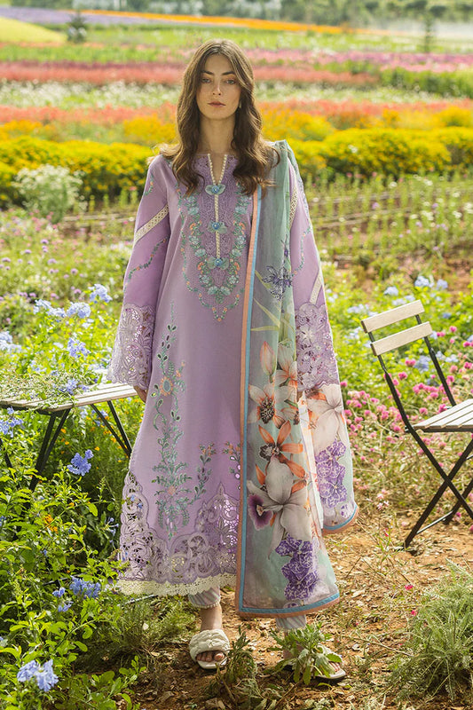 Woman in a lavender embroidered outfit standing in a colorful flower field